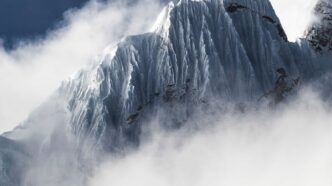 Senderista en montaña con paisaje verde